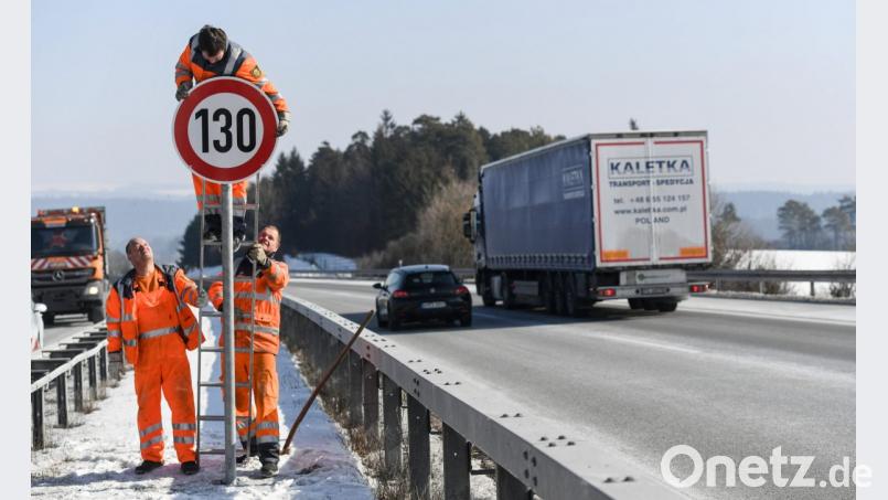 Straßenwärter montieren an der Autobahn ein Schild mit der Begrenzung auf Tempo 130. Bild: Patrick Seeger/dpa