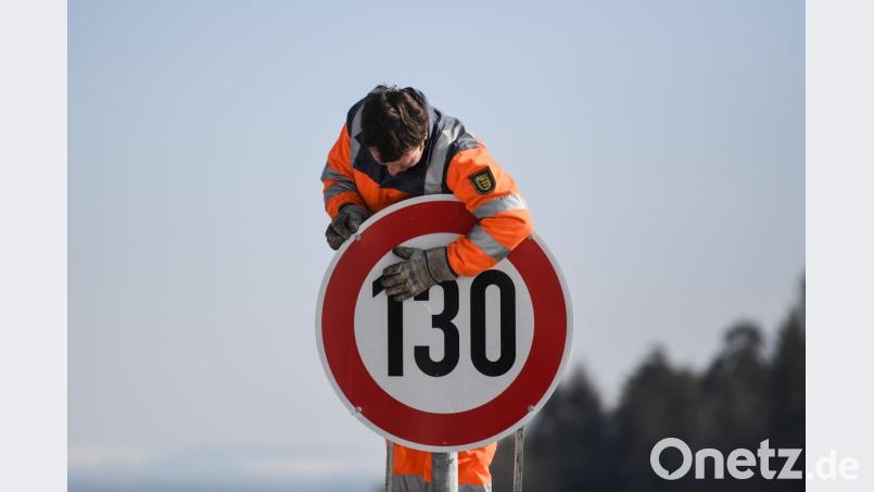Ein Straßenwärter montiert an einer Autobahn ein Schild zur Geschwindigkeitsbegrenzung. Bild: Patrick Seeger