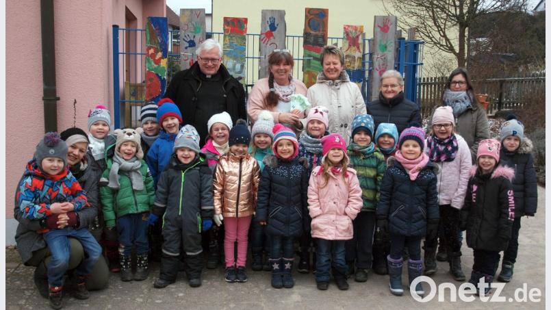 Gerlinde Hafenbradl und Rita Brem-Wittmann von der Ensdorfer Siedlergemeinschaft überreichten 300 Euro an Kindergartenleiterin Doris Bruckner. Pfarrer Gottfried Schubach (hinten) freuten sich gemeinsam mit den Kindern und den Kinderpflegerinnen Heidi Rauscher-Berndt (hinten rechts) und Bianca Hammer (kniend links) darüber. Bild: sön