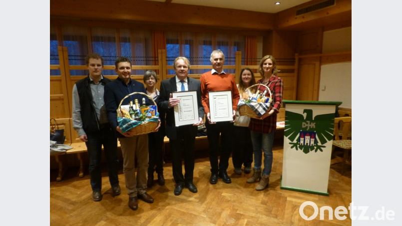 Vorsitzender Matthias Sauer (Zweiter von links) und Stellvertreterin Katrin Hochstetter (rechts) überreichen an Werner Sauer (Mitte) und Jo Bergler (Dritter von rechts) die Ernennungsurkunde zum Ehrenmitglied in der DJK und einen Geschenkkorb. Bild: ser