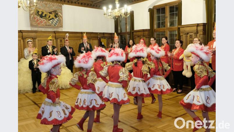 Zu Beginn der heißen Phase des Faschings gibt die Kindergarde der Narrhalla Rot-Gelb unter den Augen ihres Präsidenten Jürgen Mühl (Dritter von links) und der Prinzenpaare Oberbürgermeister Michael Cerny (Vierter von links) im Rathaus eine Kostprobe ihres Könnens. Bild: Susanne Schwab, Stadt Amberg