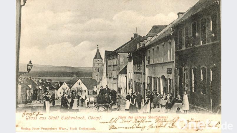 So sah das Eschenbacher Zentrum vor über 100 Jahren aus: Die vor 1904 erschienene Postkarte zeigt den Blick in Richtung Kirchturm. 1907 wurde sie mit Namenstagsgrüßen nach Erlenbach versandt. Nun ist sie in der aktuellen Ausstellung des Heimatvereins im „Taubnschuster“-Anwesen zu sehen. Repro: hev