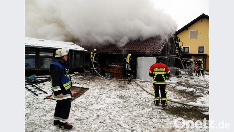 Die Holzvorräte in der Scheune sorgten für erhebliche Rauchentwicklung. Die Feuerwehrleute gingen unter schwerem Atemschutz gegen die Flammen vor und verhinderten ein Übergreifen auf das Wohnhaus. Kreisbrandmeister Armin Jehl koordinierte den Einsatz. Bild: Hösamer