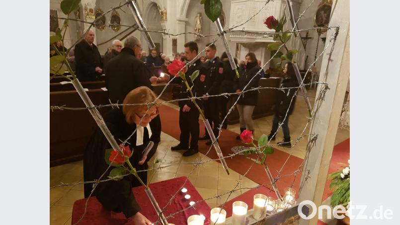 Das Gottesdienst-Team des Pfreimder &quot;Bündnis gegen Rechts&quot; gestaltete mit Pfarrer P. Georg von der katholischen Pfarrgemeinde und der evangelischen Pfarrerin Irene Friedrich (im Vordergrund) in der Pfarrkirche den ökumenischen Gottesdienst anlässlich des Gedenktages für die Opfer des Nationalsozialismus. Eindrucksvoll wurden an einem Stacheldraht Rosen geheftet, um zu mahnen: &quot;Wo Recht zu Unrecht wird, wird Widerstand zur Pflicht&quot;. Bild: hir