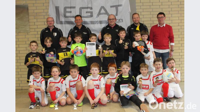 DJK-Vorsitzender Wolfgang Schwarz (stehend, rechts) und Organisator, Jugendleiter Jo Herbrecher (stehend, links), nahmen die Siegerehrung bei den F-Junioren vor. Im Spiel im Platz eins schlug der FC Vorbach (stehend) die Kicker der DJK Neustadt I (kniend) knapp mit 1:0. Bild: prh