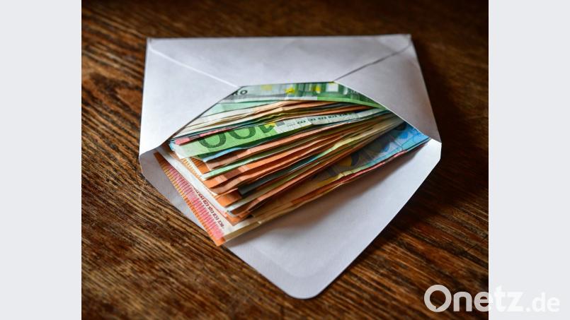 Mehrere Eurobanknoten liegen in einem Briefumschlag auf einem Tisch. Bild: Patrick Pleul/ZB/dpa