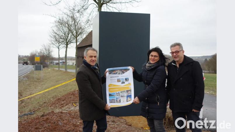 Bürgermeister Roland Grillmeier, Gabi Bleistein von der Tourist-Info und Geschäftsleiter Klaus Schüßler (von links) präsentieren ein Infoplakat vor einer der neuen Stelen, hier an der Waldsassener Straße. Die künftigen Infotafeln auf allen vier Seiten werden etwa doppelt so groß sein wie das Plakat. Bild: lnz