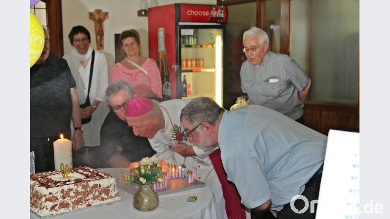 Beim Ausblasen der vielen Geburtstagskerzen wird Bischof Lobinger von Stadtpfarrer Hannes Lorenz (links) und Bürgermeister Armin Schärtl (rechts) nach Kräften unterstützt. Bild: bph