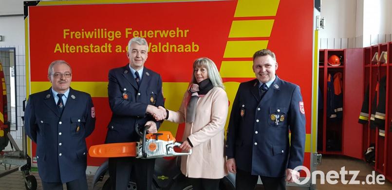 Über eine Motorsäge im Wert von 1000 Euro, die Gabi Prockl überreicht, freuen sich die Verantwortlichen der Feuerwehr Altenstadt/WN. Bild: adj