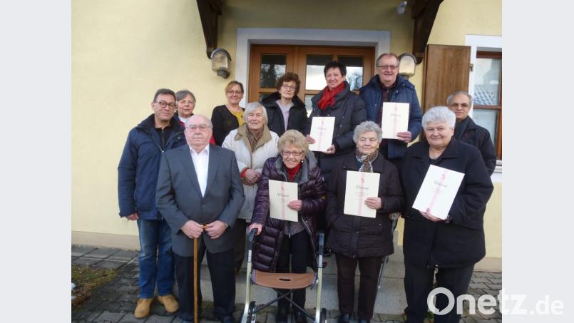 Teamsprecher Martin Eheim(links) und Präses Varghese Puthenchira (rechts) ehrten langjährige Mitglieder. Seit 60 Jahren gehören zur KAB Hans Solfrank und Rita Neumann (vorne 1. und 3. von links). Bild: bk
