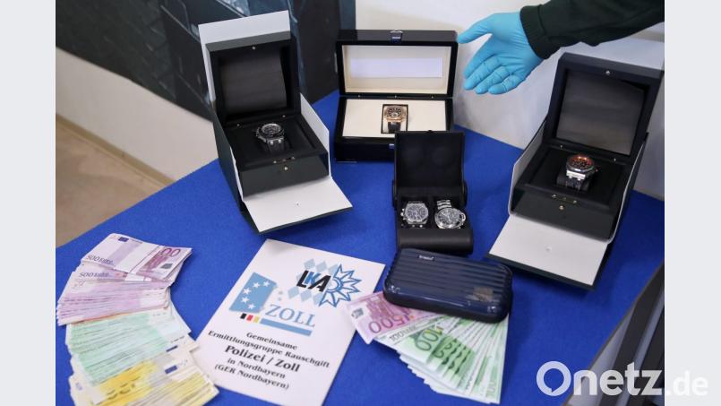 Bargeld, Uhren und eine Schusswaffe liegen im Zollfahndungsamt auf einem Tisch. Bild: Daniel Karmann