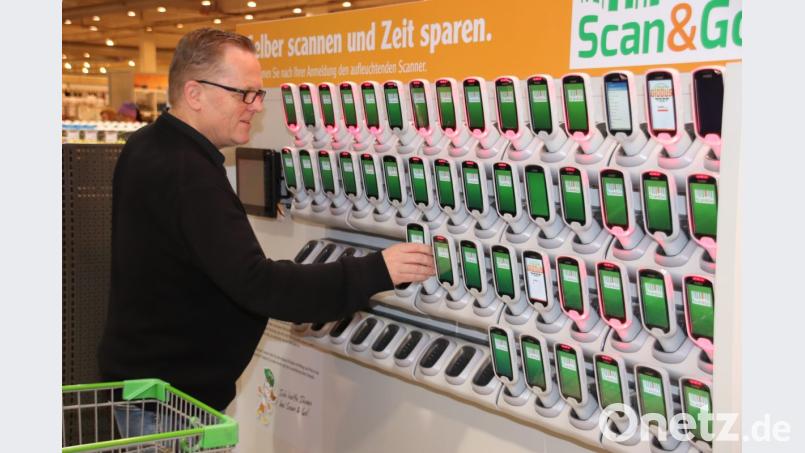 Reiner Debernitz, der Leiter des Globus-Warenhauses im Stadtosten von Schwandorf, probiert schon einmal die neue Scanner-Station am Eingang aus. Nachdem man sich mit einer Karte angemeldet hat, kann man einen der handlichen Scanner entnehmen und in eine Halterung am Einkaufswagen stecken. Damit geht es dann durch den Markt. Bild: Thomas Dobler