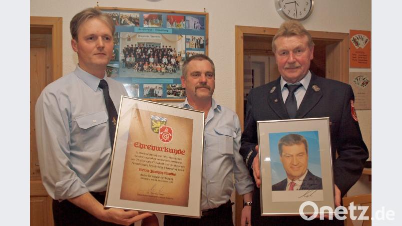 Mit einer Ehrenurkunde des Feuerwehrvereins und einem handsigniertem Bild von Ministerpräsidenten Markus Söder dankten stellvertretender Vorsitzender Christian Richthammer und Beisitzer Jürgen Hofmeister (von links) dem langjährigen Vorsitzenden Joachim Hantke (rechts). Bild: sön