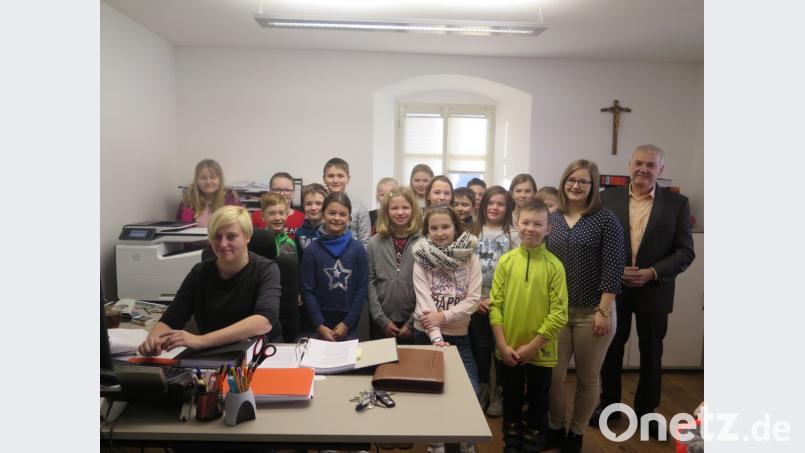 Geschäftsstellenleiterin Kathrin König (sitzend) und Bürgermeister Günter Kopp (rechts) erklären den Viertklässlern und ihrer Lehrerin Anna Hofmann (Zweite von rechts) ihre Aufgabengebiete. Bild: jzk