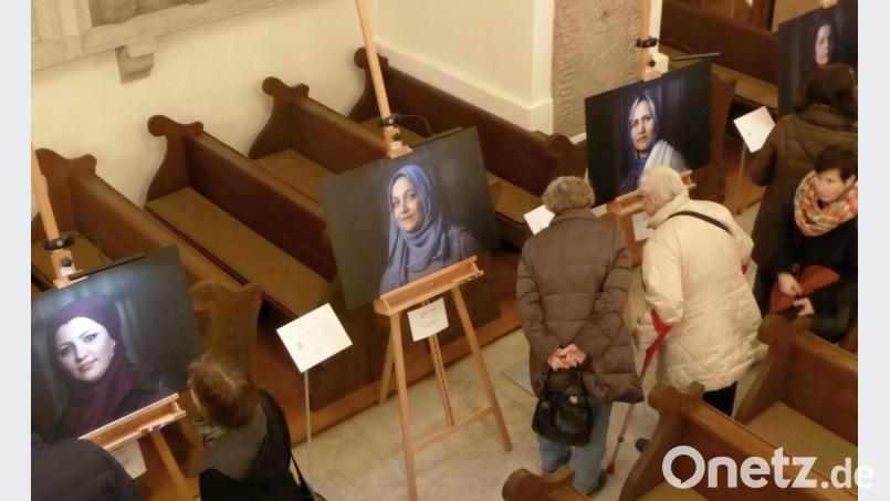 Besucher betrachten die Porträts junger Flüchtlingsfrauen Bild: fsb