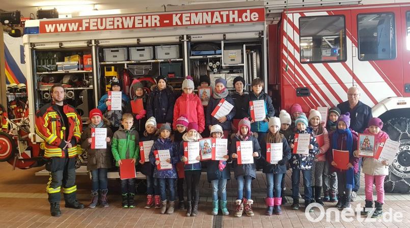 Brandschutzerzieher und Kreisbrandinspektor Otto Braunreuther (hinten rechts) sowie Feuerwehrmann Daniel Merkl (links) zeigen den Grundschülern die Ausrüstung der Kemnather Feuerwehr und das richtige Verhalten bei ein Notfall. Am Ende gibt es für sie alle Urkunden. Bild: mde