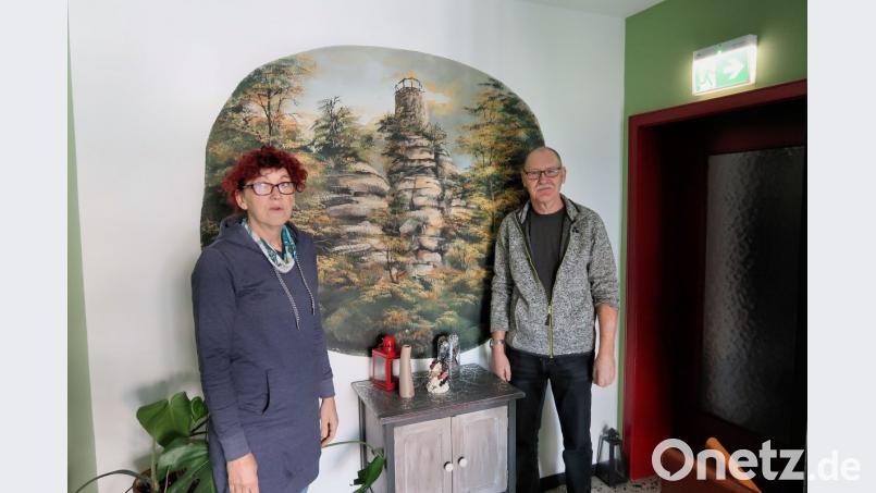 Im Flur der Pension grüßt ein Gemälde, das den Weißenstein im Steinwald zeigt, die ankommenden Gäste. Sabine (links) und Stefan Friebus wissen mittlerweile viel über das herrliche Wandergebiet und beraten ihre Gäste auch bei ihren Ausflügen. Bild: bsc