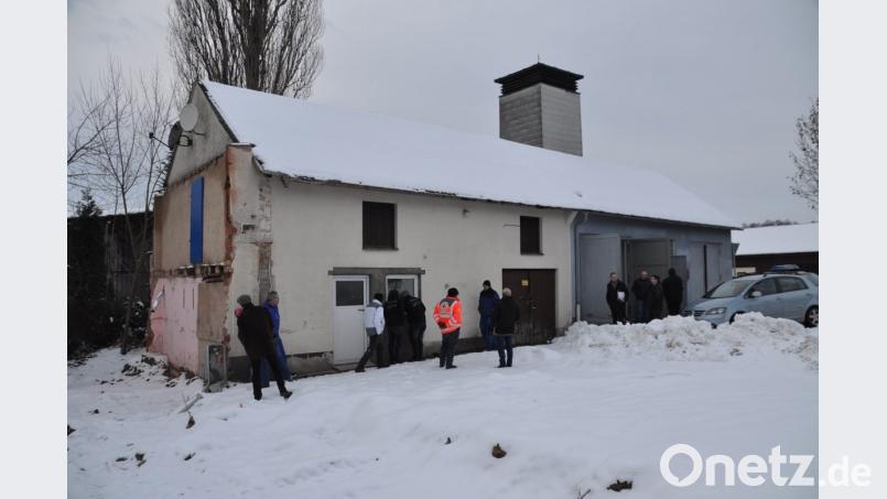 An der Südseite des alten Feuerwehrgerätehauses (rechts) und des Anbaus nimmt der Bauausschuss die beiden Garagen, die für die Brandschützer bestimmt sind, sowie die künftigen Räume für die Helfer vor Ort (links) in Augenschein. Bild: ak