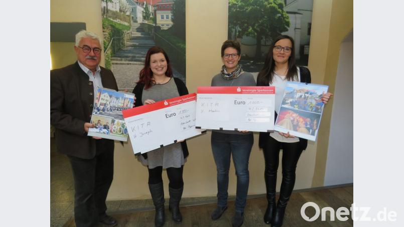 Bürgermeister Ruppert Troppmann (links) und Geschäftsführerin Sonja Skutella (rechts) von Fotobuch.de überreichen jeweils 1000 Euro an die Leiterinnen der beiden Kindergärten Katharina Pfistermeister (Zweite von links) des Kindergarten St. Joseph und Theresa Uhl (Zweite von rechts) des Kindergarten St. Martin. Bild: adj
