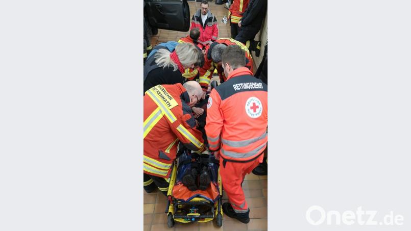 Daniel Merkl (vorne rechts) erläutert die Bedienung der Patiententrage. Stefan Binner (hinten, Mitte) übt mit den Feuerwehrleuten die Anwendung der Schaufeltrage und des &quot;KED-Systems&quot;. Bild: mde