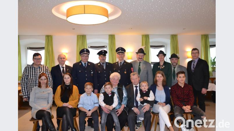 Richard Götzfried, mit dem zweijährigen Jonathan auf dem Schoß, feiert seinen 80. Geburtstag. Dazu gratulieren seine Frau Erna, die Enkelkinder, Pfarrer Josef Most (Zweiter von links) und Bürgermeister Hermann Ach (rechts) sowie die Abordnungen der Feuerwehr und des Schützenvereins Heumaden. Bild: gi