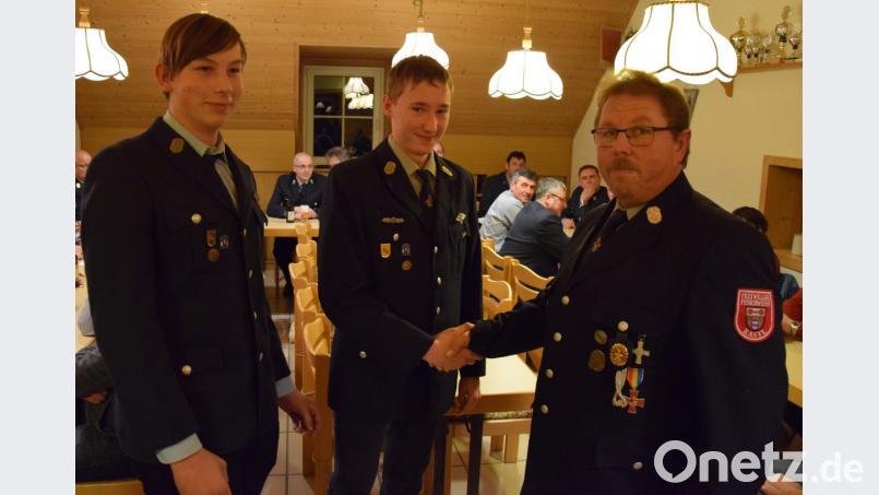 Kommandant Ludwig Kugler (rechts) nimmt Jonas Zeitler (Mitte) und Bastian Wagner (links) per Handschlag in den aktiven Feuerwehrdienst auf. Bild: mde