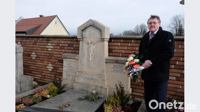 Bürgermeister Hans-Martin Schertl legt ein Blumengebinde am Grab des verstorbenen Altbürgermeister Rudolf Merkl nieder. Bild: Stefanie Gradl