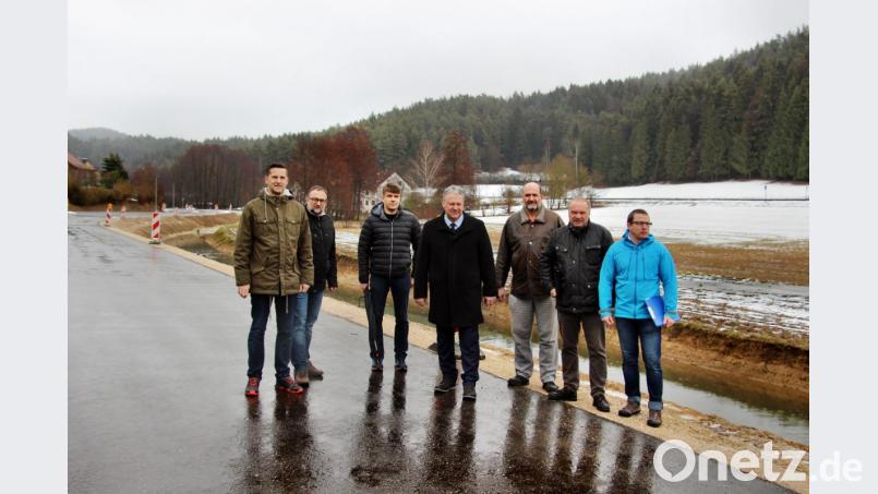Etzelwangs Bürgermeister Roman Berr, Hubert Engelhard und Gerald Lord vom ausführenden Bauunternehmen Engelhard, Landrat Richard Reisinger, Manfred Stollner vom Bauamt der Verwaltungsgemeinschaft Neukirchen, Architekt Manfred Lubrich und Matthias Kolb vom Tiefbauamt (von links) schreiten den Abschnitt mit der noch fehlenden Asphaltdeckschicht und dem neuverlegten Bachbett ab, um einen Überblick über die erforderlichen Restarbeiten zu gewinnen. Bild: ds