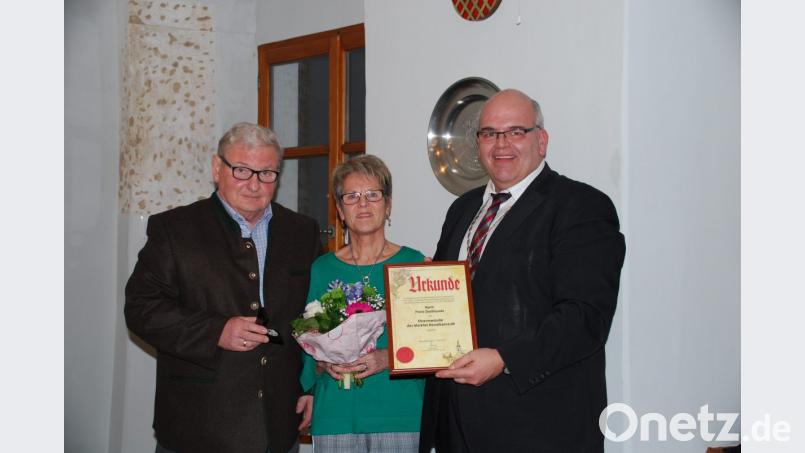 Bürgermeister Klaus Meyer (rechts) überreichte an Franz Danhauser (links) die Ehrenmedaille der Marktgemeinde. Einen Blumenstrauß erhielt Evi Danhauser. Bild: enz