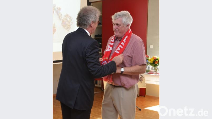 Alfons Raab überreicht an Hausmeister Werner Fleißner einen FC-Bayern-Fan-Schal. Bild: dob