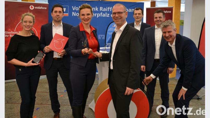 Den Kabelsalat, den Andrea Kraus von Vodafone und Thomas Wirth, Vorstand der Bank (vorne, von links), in den Händen halten, ist ein aufgedröseltes hochmodernes Glasfaser-Kabel. Bild: Beate-Josefine Luber