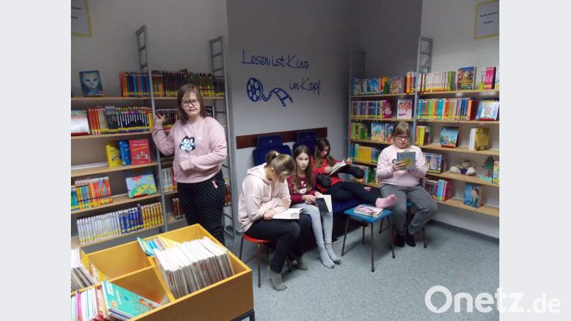 Schülerinnen der Ganztagsklasse stöbern in den Bücherregalen. Bild: jbe