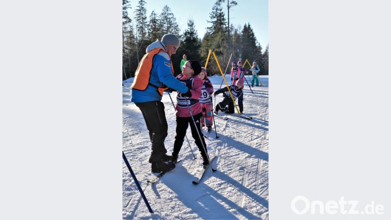 Verschiedene Stationen mussten die Kinder absolvieren, zum Beispiel Schlupftore. Trainer Martin Grünwald gibt ihnen Tipps. Bild: chl