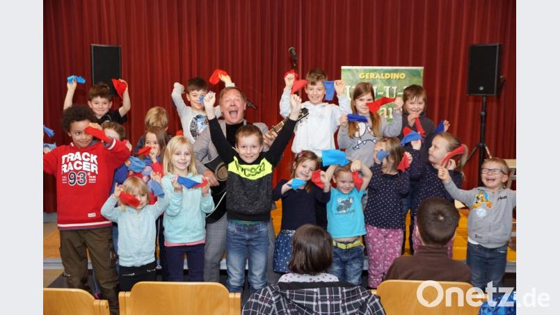 Wo Geraldino (Gerd Grashaußer, mit Gitarre) ist, sind Kinder nicht weit. Auch bei seinem Auftritt im SOS-Kinderdorf umringen ihn die Mädchen und Buben bei seinem Mitmachkonzert. Bild: bkr