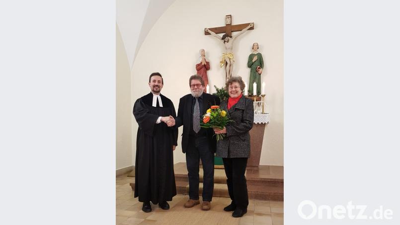 Pfarrer Stefan Fischer (links) dankte Ulrich Gerlach für dessen Engagement in der evangelischen Kirchengemeinde. Evelin Gerlach bekam einen Blumenstrauß. Bild: wku
