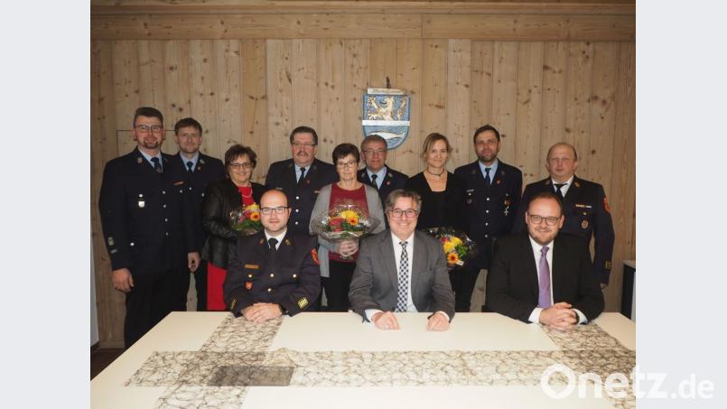 Landrat Andreas Meier verleiht im Beisein von Bürgermeister Reiner Gäbl und Kreisbrandrat Marco Saller (vorne, von rechts) das Feuerwehrehrenabzeichen in Gold und Silber an Markus Lehner (hinten, Zweiter von rechts), Thomas Kleber (stehend, Vierter von links) und Kommandant Josef Kleber (stehend, Sechster von links). Bild: gz