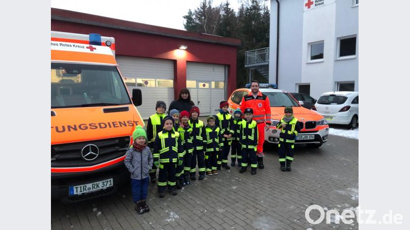 Daniel Merkl (hinten rechts) zeigt den Löschzwergen und Angelika Karl (hinten links) den Fuhrpark der Kemnather BRK-Bereitschaft. Am Ende verfrachten sie gemeinsam ihre Betreuerin in den Sanka. Bild: exb