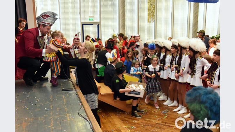 Während die Jugendgarde das Spalier zur Krapfenpolonaise bildet und die Helfer des Vereins das leckere Schmalzgebäck verteilen, überreicht Präsident Daniel Sommer eine kleine Clown-Dame, die sich auf der Bühne verirrt hatte, an deren Mama. Bild: bgm