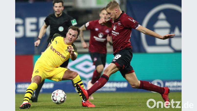 Der Nürnberger Hanno Behrens (r) kämpft mit dem Dortmunder Mario Götze um den Ball. Bild:  Daniel Karmann/dpa