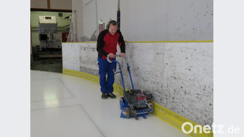 Stefan Pelz fährt mit dem Bandenschleifer die Ränder ab. Sie sollten etwas tiefer liegen als die übrige Eisfläche. Bild: ubb