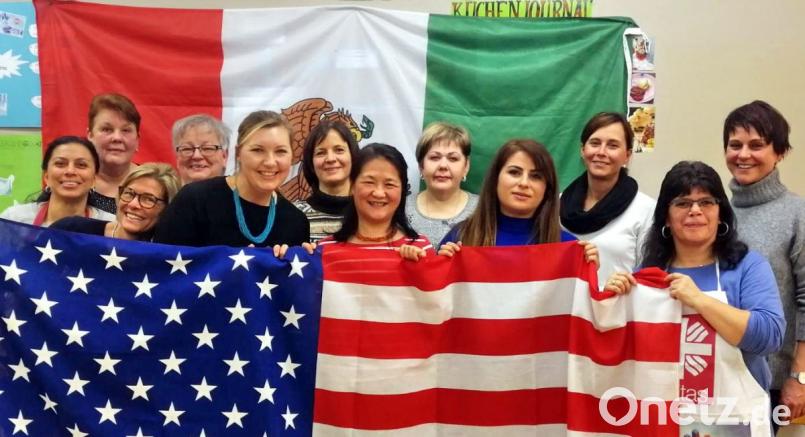 Was US-Präsident Donald Trump auf der anderen Seite des Atlantiks trennen möchte, gehört in Speichersdorf zusammen. Das 60. Treffen der Internationalen Kochgruppe steht unter dem Motto „Tex-Mex-Fiesta“. Dazu hat Leiterin Dolores Longares-Bäumler (vorne rechts) die US-Flagge und eine Mexiko-Fahne mitgebracht. Bild: hai