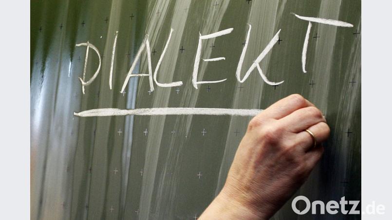 Eine Frau schreibt das Wort "Dialekt" auf eine Tafel. Foto: Daniel Karmann/Archiv Bild: Daniel Karmann