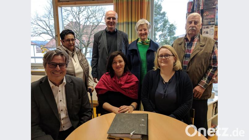 An diesem Tisch in der Eslarner Bibliothek wird Noemi Roupcova (vorne, Mitte) künftig alle zwei Wochen Geflüchtete beraten. Unterstützt wird sie von stellvertretender Sozialteam-Leiterin Ursula Hösl (vorne, rechts), Bürgermeister Reiner Gäbl (vorne, links) sowie (hinten, von links) Vermieterin Monika Brunner mit Mann Erich (rechts), Integrationslotse Wolfgang Klink und Anita Weichselmann. Bild: Konrad