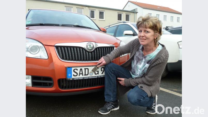 Alexandra Vogl entstempelt das Kennzeichen durch Abkratzen der amtlichen Plakette. Dies darf der Halter des Fahrzeugs nicht selbstständig, sondern nur unter Aufsicht der Behördenmitarbeiter vornehmen. Bild: Portner