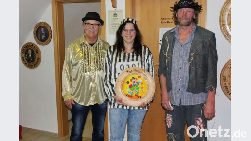 Zweiter Schützenmeister Helmut Schötz (links) und Sportleiter Ernst Kölbel (rechts) überreichen die Faschingsscheibe an Tanja Hüttner. Bild: sis