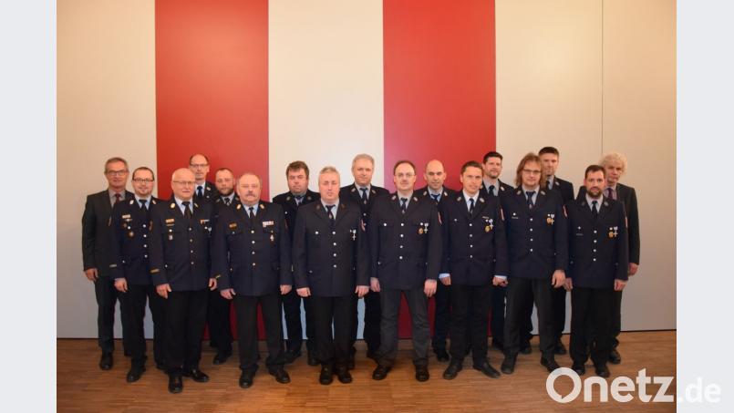 An die Uniformjacke von 12 der 13 für 25-jährige aktive Feuerwehrdienstzeit ausgezeichneten ehrenamtlichen Feuerwehrleuten können Landrat Wolfgang Lippert (rechts) und Kreisbrandrat Andreas Wührl (Sechster von links) die Feuerwehrehrenkreuze in Silber anbringen und die Urkunden überreichen. Ihnen gratulieren Bürgermeister Werner Nickl und KBM Florian Braunreuther (links) sowie KBM Alois Schindler (Vierter von links). Bild: mde
