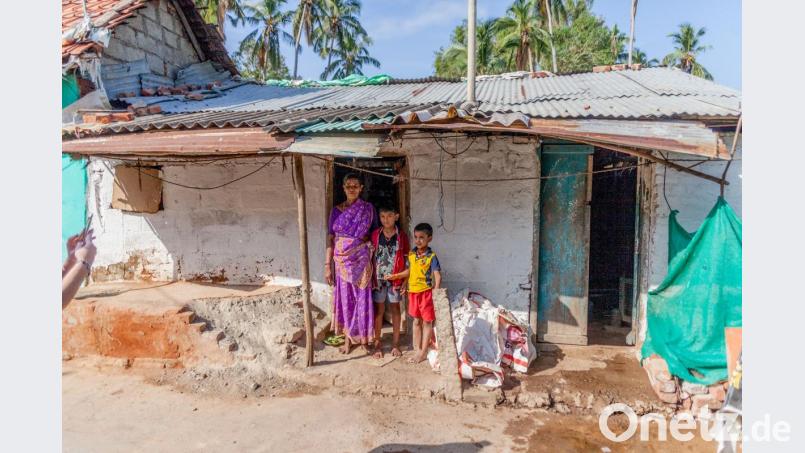 In den Slums in Südindien steht eine Witwe mit ihren zwei Kindern vor ihrer Hütte. Bild: Christian Höllerer/exb