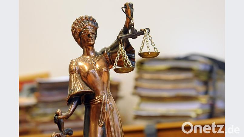Eine goldfarbene Justitia-Figur steht vor Aktenbergen. Bild: Britta Pedersen