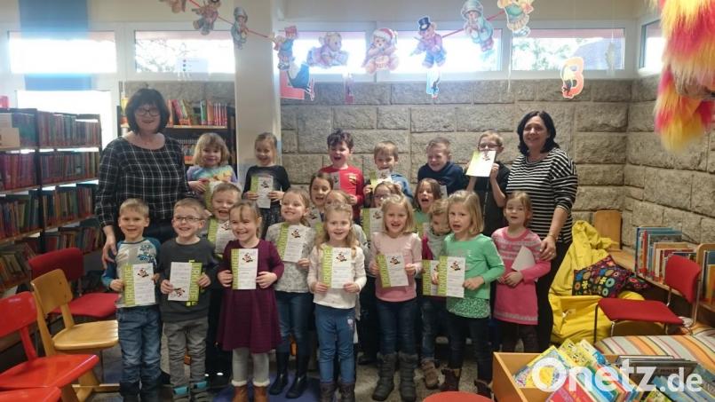 Stolz präsentieren die Mädchen und Buben des katholischen Kindersgartens beim Abschlussfest in der Marktbücherei ihren Büchereiführerschein. Bild: exb