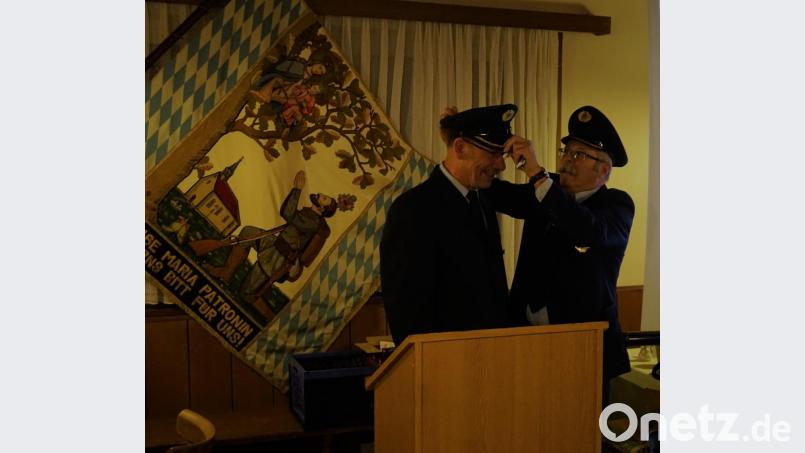 Ehrenvorsitzender Graml Bernhard übergibt den Vorstandshut an Uwe Preißler, den neu gewählten Vorsitzenden. Bild: brü